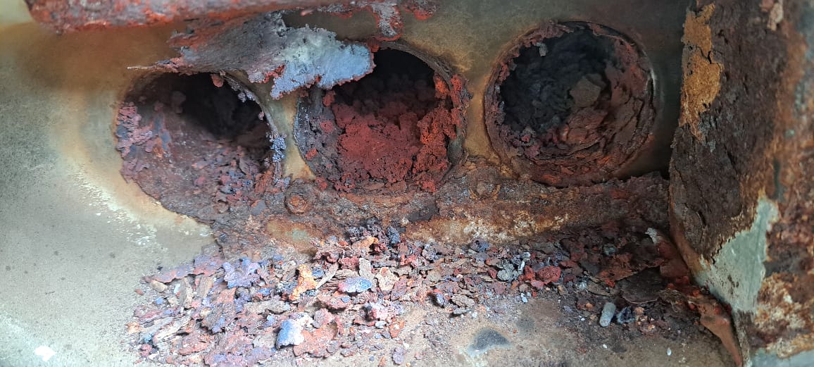 Cámara de combustión de rooftop tapada por óxido y hollín antes de la reparación